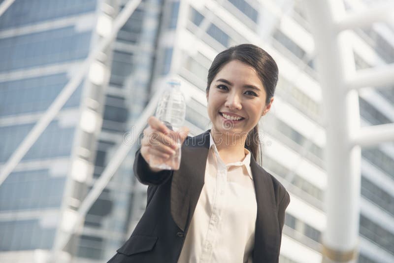 Knappe toont de portret jonge Aziatische onderneemster waterfles stock afbeelding Knappe toont de portret jonge Aziatische onderneemster waterfles stock afbeelding