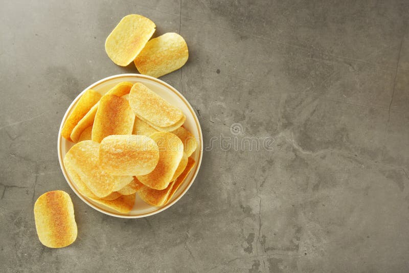 Knapperige die chips over grijze geweven achtergrond worden geïsoleerd Hoogste mening De ruimte van het exemplaar stock foto Knapperige die chips over grijze geweven achtergrond worden geïsoleerd Hoogste mening De ruimte van het exemplaar stock foto