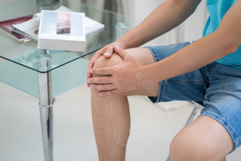 Knee Pain, Man Suffering from Ache and Doing Selfmassage at Home Stock