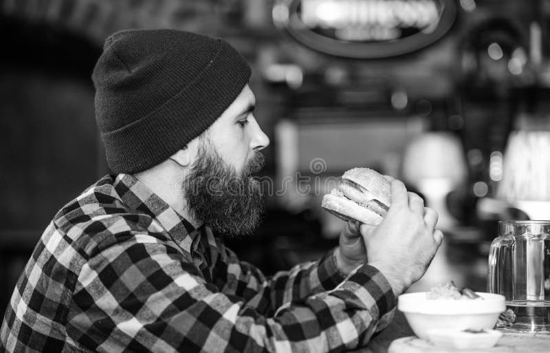 Kneipe entspannt sich Platz, um Getr?nk zu haben und sich zu entspannen Mann mit Bartgetr?nkbier essen Burgermen? Genie?en Sie Ma lizenzfreies stockbild Kneipe entspannt sich Platz, um Getr?nk zu haben und sich zu entspannen Mann mit Bartgetr?nkbier essen Burgermen? Genie?en Sie Ma lizenzfreies stockbild