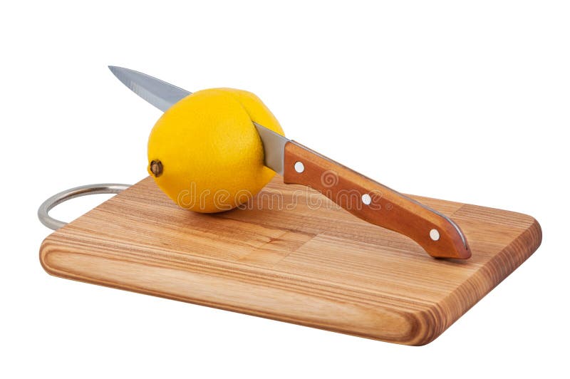 Knife cuts lemon on cutting board.