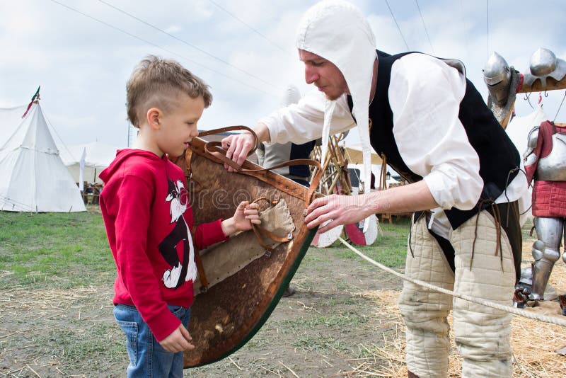 Knight shows the shield to a child