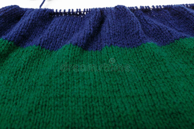Knit Striped Green Blue Fabric on Knitting Needle in Process. Texture