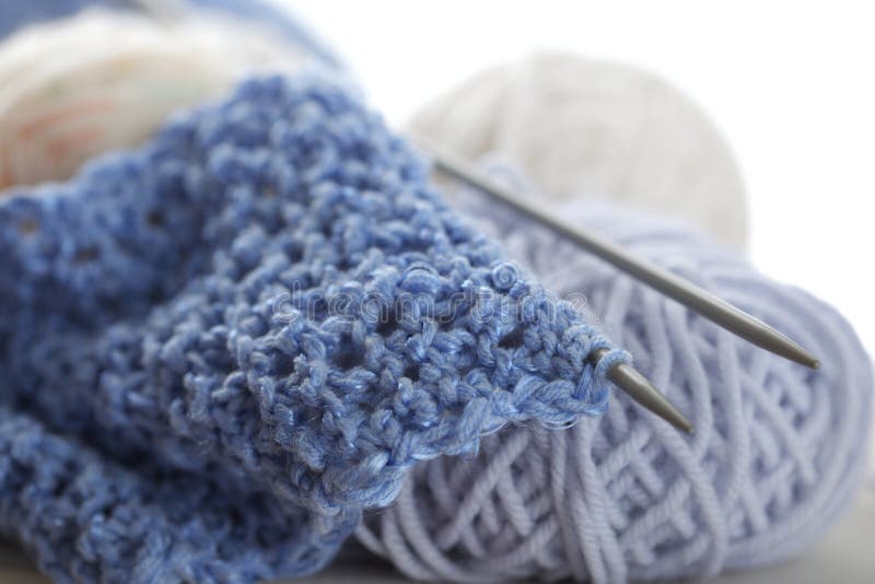 Knitting with blue wool, on knitting needles and balls; shallow DOF as arts effect