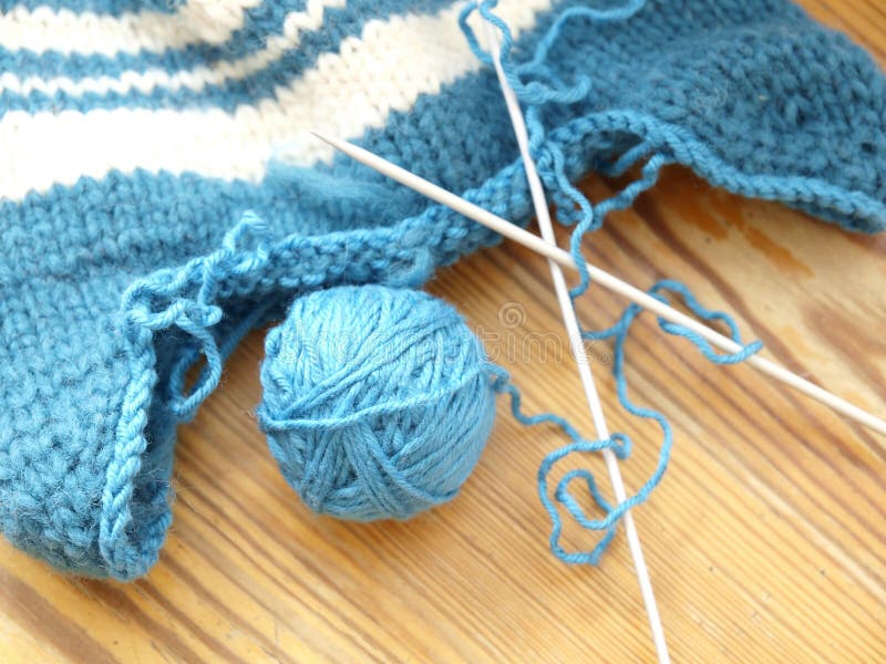 Knitting wool and needles on a wooden table