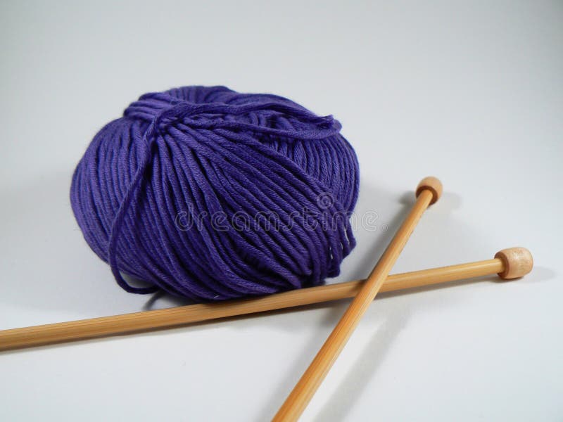 Ball of blue yarn with bamboo knitting needles