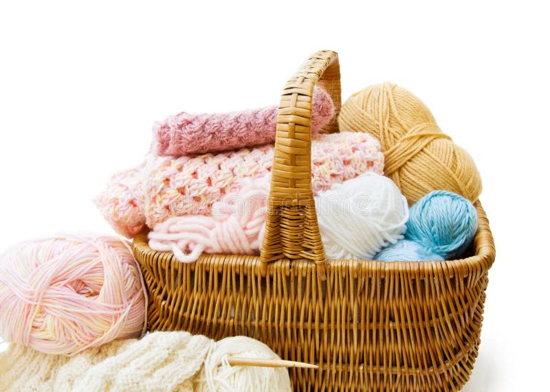 Knitting. Wicker basket with colored balls of wool yarn and crochet hooks  on wooden background. Stock Photo