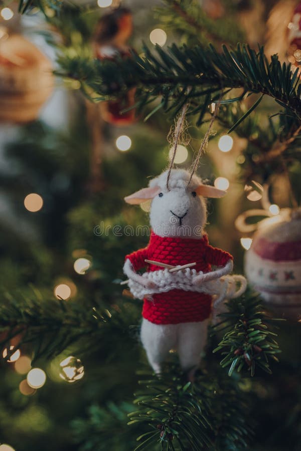 Knitting sheep in a red jumper felt Christmas decoration on a Christmas tree