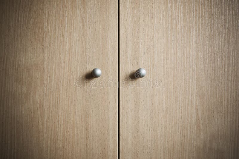 Knobs. Two metal knobs on a wooden cabinet. Door knobs stock images, royalty-free photos and pictures