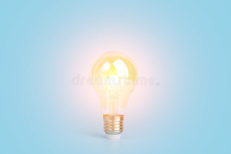 Knowledge and idea concept. Light bulb with light on a blank blue background. Brain, wisdom, knowledge and energy royalty free stock photos