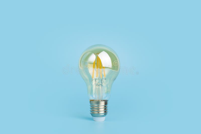Knowledge and idea concept. Light bulb with light on a blank blue background. Brain, wisdom, knowledge and energy royalty free stock photos