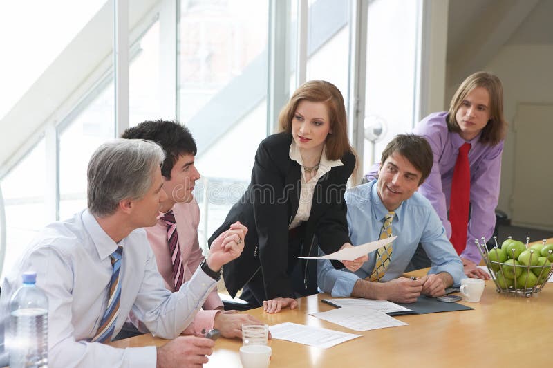 She knows. Five businesspeople are discussing something on a meeting She knows. Five businesspeople are discussing something on a meeting