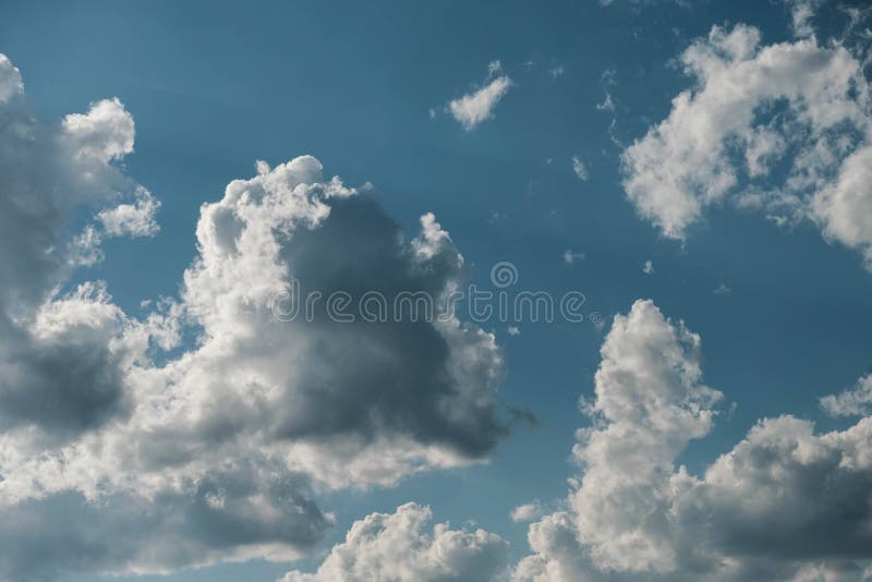 Knusprige weiße Wolken umrahmt von intensivem blauen Himmel und subtilen Sonnenstrahlen