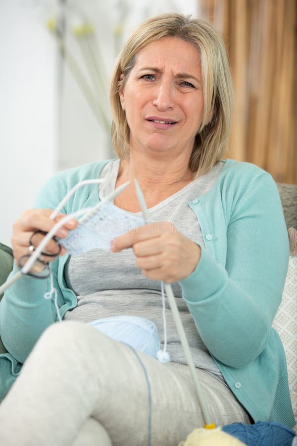 mature woman knitting with wool and knitting needles home. mature woman knitting with wool and knitting needles home