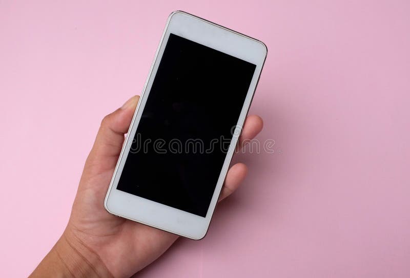 Kobieca dłoń trzymająca biały smartfon z pustym ekranem i nowoczesnym designem wyizolowanym na różowym tle. Kobieta przechowuje nowy nowoczesny smartfon z czystym czarnym ekranem - koncepcja komunikacji mobilnej wyizolowana na niebieskim tle z przestrzenią kopiowania