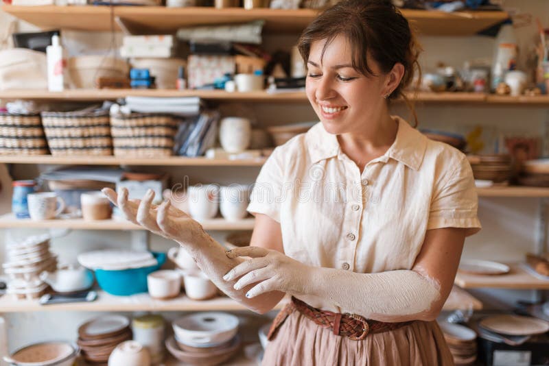 Kobiece dłonie główne pokryte gliną, ceramiką