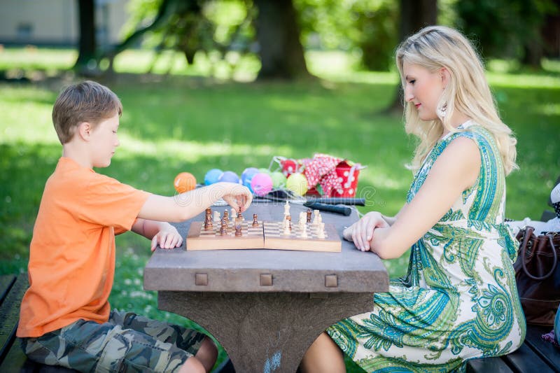 Kobieta bawić się szachy z jej synem