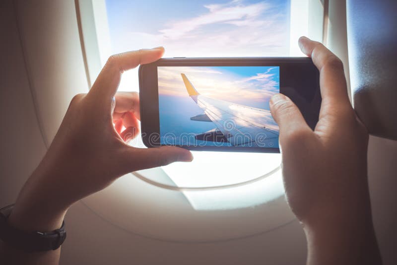 Kobieta bierze fotografię z smartphone na samolocie Wakacyjna podróż zdjęcie royalty free Kobieta bierze fotografię z smartphone na samolocie Wakacyjna podróż zdjęcie royalty free