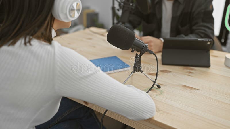 Kobieta i mężczyzna współpracują podczas sesji nagrań podkastowych w nowoczesnym studio wnętrzu zdjęcie stock