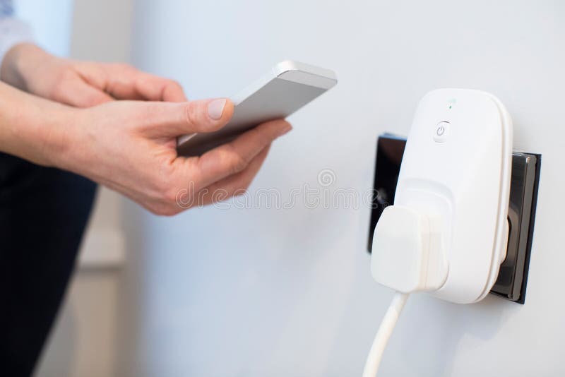 Kobieta Kontroluje Mądrze Wtyczkowego Używa App Na telefonie komórkowym zdjęcie stock
