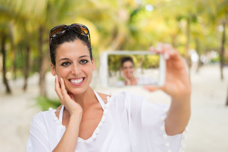 Kobieta na tropikalnej plaży smartphone selfie urlopowej bierze fotografii obraz royalty free Kobieta na tropikalnej plaży smartphone selfie urlopowej bierze fotografii obraz royalty free