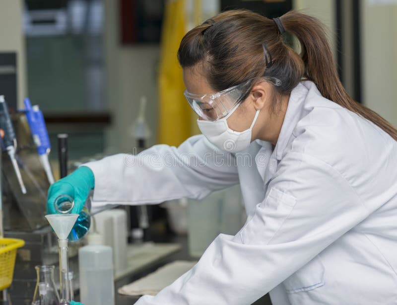 Kobieta naukowa opłukania substancje chemiczne w próbnego szkło zdjęcie stock