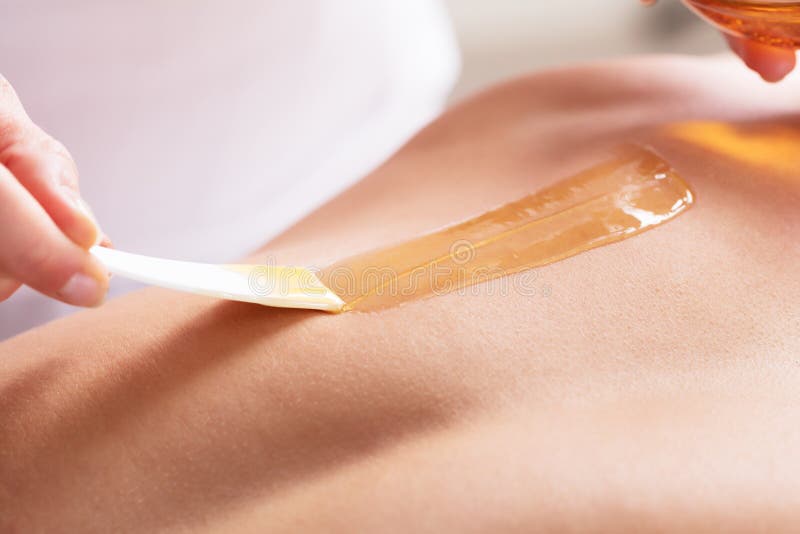 Close-up Of A Woman Waxing Man`s Chest With Wax Strip. Close-up Of A Woman Waxing Man`s Chest With Wax Strip