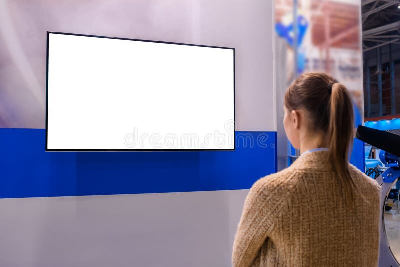 Kobieta patrząca na białą pustą ścianę wystawową na białym ekranie