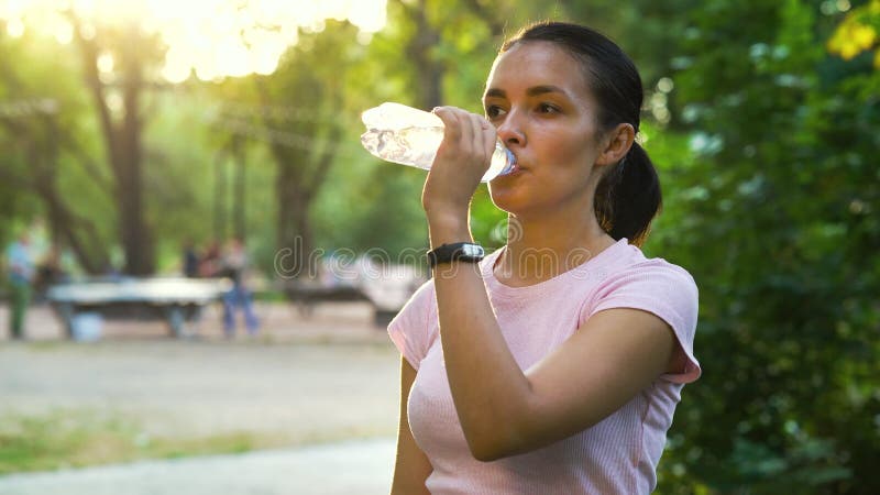 Kobieta pijąca wodę po szkoleniu na zewnątrz