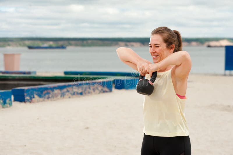 Kobieta podnosząca ciężar kettlebella na sali fitness na zewnątrz. fotografia stock