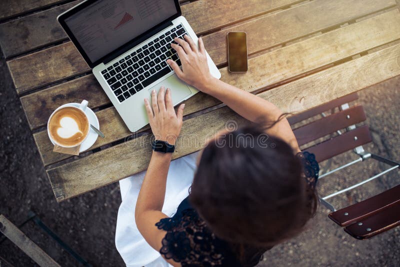 Kobieta pracuje na jej laptopie przy plenerową kawiarnią zdjęcie stock Kobieta pracuje na jej laptopie przy plenerową kawiarnią zdjęcie stock