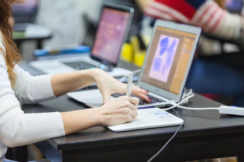 Kobieta projektanta rysunek w laptopie z graficzną pastylką, zamyka w górę widoku ręka z piórem obraz stock Kobieta projektanta rysunek w laptopie z graficzną pastylką, zamyka w górę widoku ręka z piórem obraz stock
