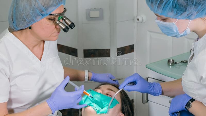 Kobieta przy dentysta kliniką dostają stomatologicznego traktowanie wypełniać zagłębienie w zębie Stomatologiczny przywrócenie i fotografia stock Kobieta przy dentysta kliniką dostają stomatologicznego traktowanie wypełniać zagłębienie w zębie Stomatologiczny przywrócenie i fotografia stock