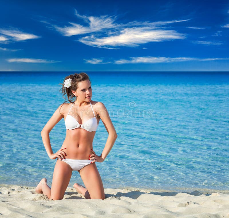 Kobieta relaksuje na tropikalnej plaży w białym pływanie kostiumu zdjęcia stock Kobieta relaksuje na tropikalnej plaży w białym pływanie kostiumu zdjęcia stock