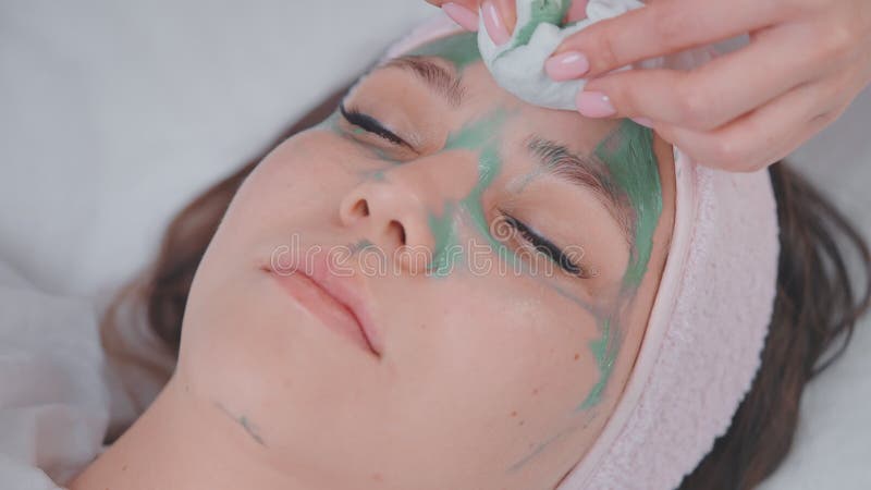 Kobieta relaksuje się i cieszy się w salonie spa widok na kobiecą twarz i ręce kosmetologa zdjęcie wideo
