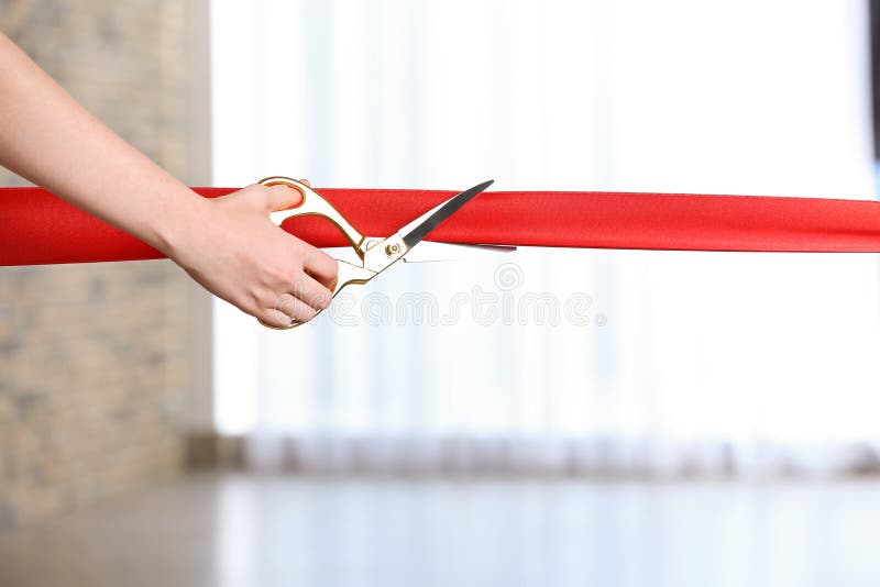 Kobieta tnący czerwony faborek fotografia stock Kobieta tnący czerwony faborek fotografia stock