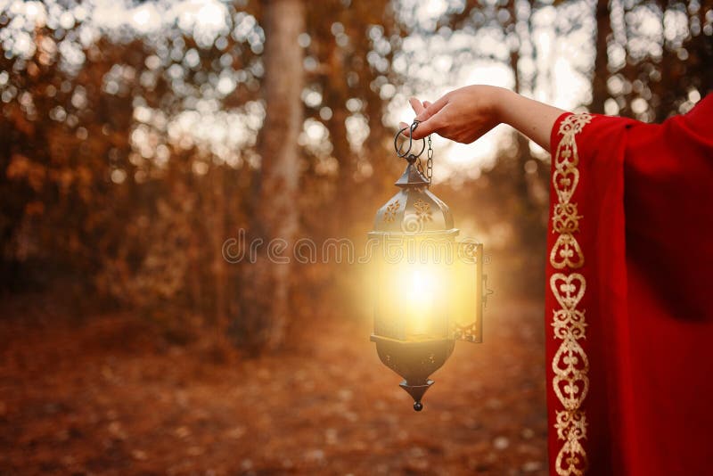 Kobieta trzymająca latarnię ze świecą