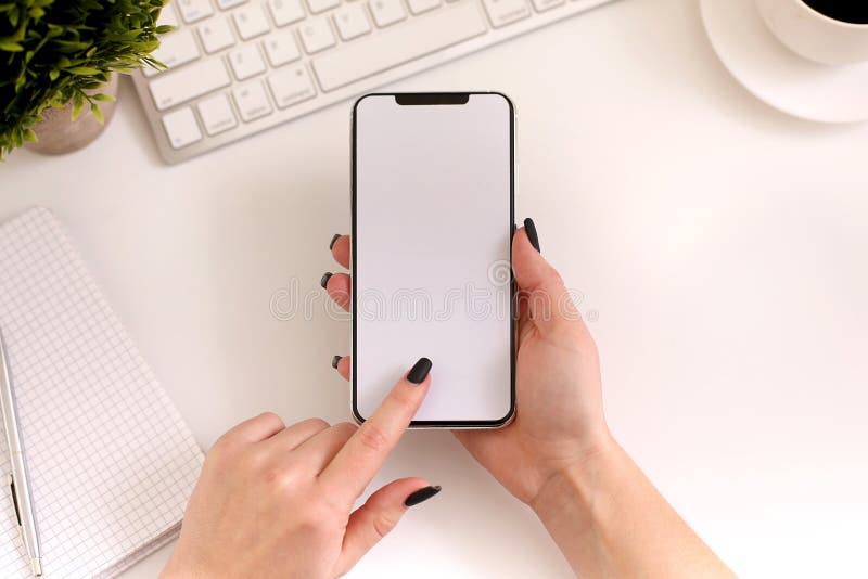 Kobieta używa smartphone przy pracą Bielu pusty ekran, odgórny widok fotografia royalty free Kobieta używa smartphone przy pracą Bielu pusty ekran, odgórny widok fotografia royalty free