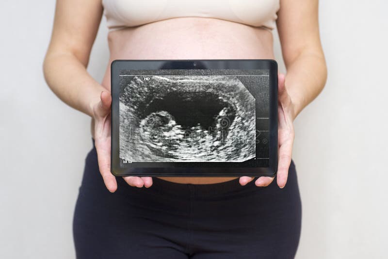 Kobieta w ciąży pokazuje obrazek dziecko ultradźwięku obraz cyfrowy na pastylce zdrowa ciąża Pojęcie Ciążowa opieka zdrowotna obrazy royalty free Kobieta w ciąży pokazuje obrazek dziecko ultradźwięku obraz cyfrowy na pastylce zdrowa ciąża Pojęcie Ciążowa opieka zdrowotna obrazy royalty free
