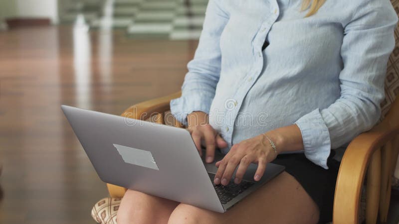 Kobieta w ciąży pracuje na laptopie