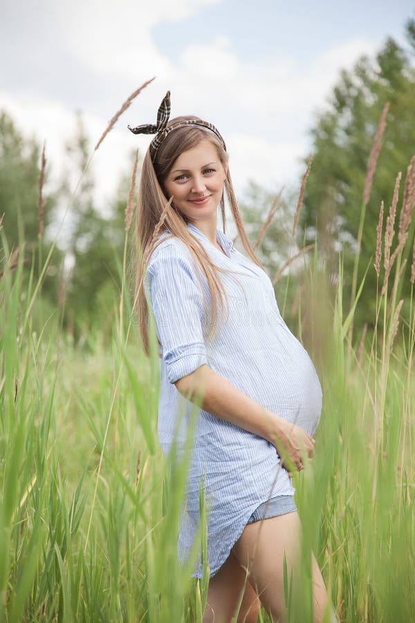 Kobieta w ciąży stojaki na łące