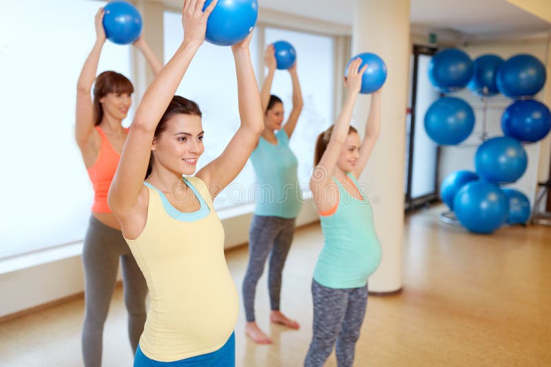 Kobieta w ciąży trenuje z ćwiczenie piłkami w gym zdjęcie royalty free Kobieta w ciąży trenuje z ćwiczenie piłkami w gym zdjęcie royalty free