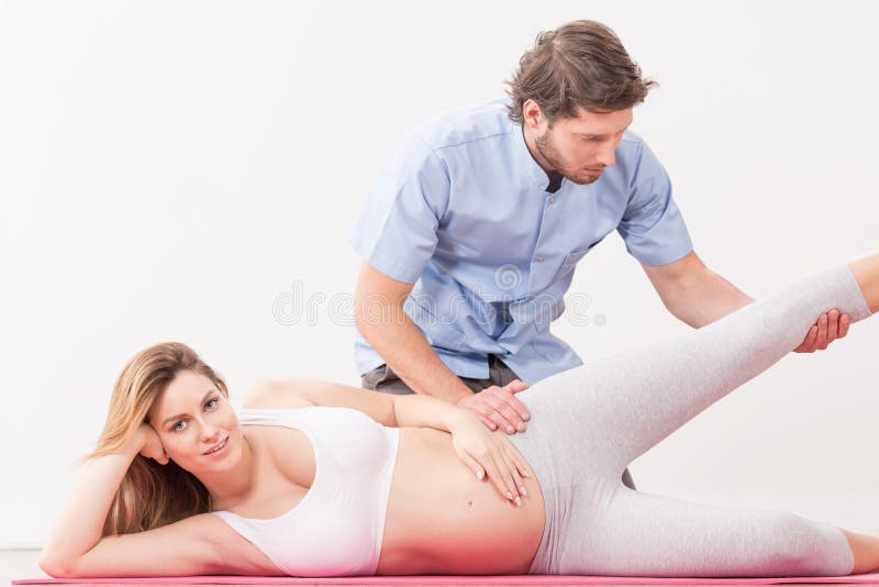 Kobieta w ciąży ćwiczy z physiotherapist zdjęcia royalty free Kobieta w ciąży ćwiczy z physiotherapist zdjęcia royalty free