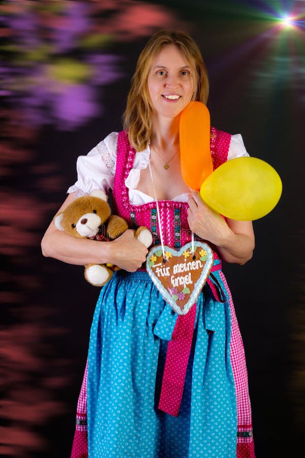 Kobieta w dirndl wygrywał niektóre nagrody przy Oktoberfest obraz stock Kobieta w dirndl wygrywał niektóre nagrody przy Oktoberfest obraz stock
