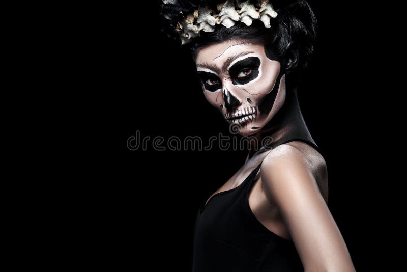 Woman in Halloween costume of Frida Kahlo on black background. Skeleton or skull makeup. Woman in Halloween costume of Frida Kahlo on black background. Skeleton or skull makeup.