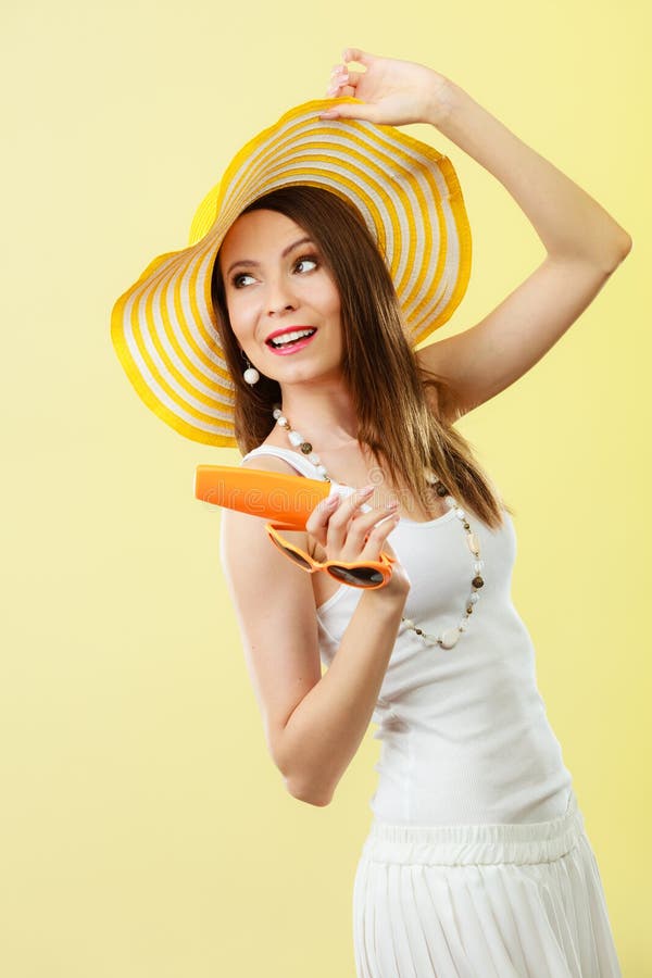 Kobieta w lato kapeluszu trzyma okulary przeciwsłoneczni sunscreen płukankę zdjęcie stock Kobieta w lato kapeluszu trzyma okulary przeciwsłoneczni sunscreen płukankę zdjęcie stock