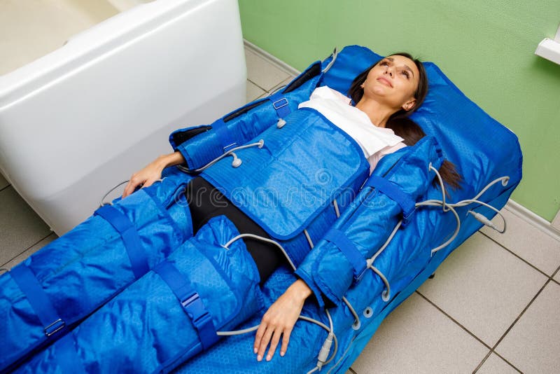 Kobieta w pressotherapy kostiumu łgarskim puszku ma ciśnieniową terapię obraz stock Kobieta w pressotherapy kostiumu łgarskim puszku ma ciśnieniową terapię obraz stock