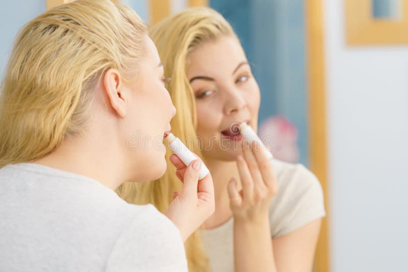 Kobieta w łazience stosująca balsam do ust zdjęcie stock