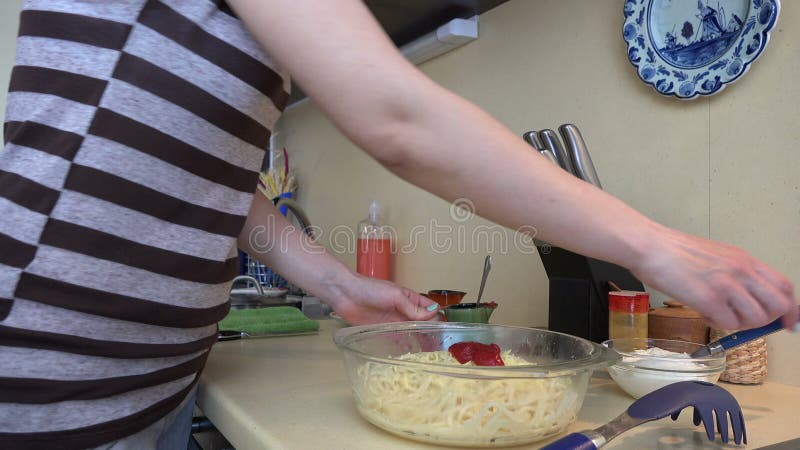 Kobieta wręcza stawiającego czerwonego kumberland na spaghetti makaronie 4K