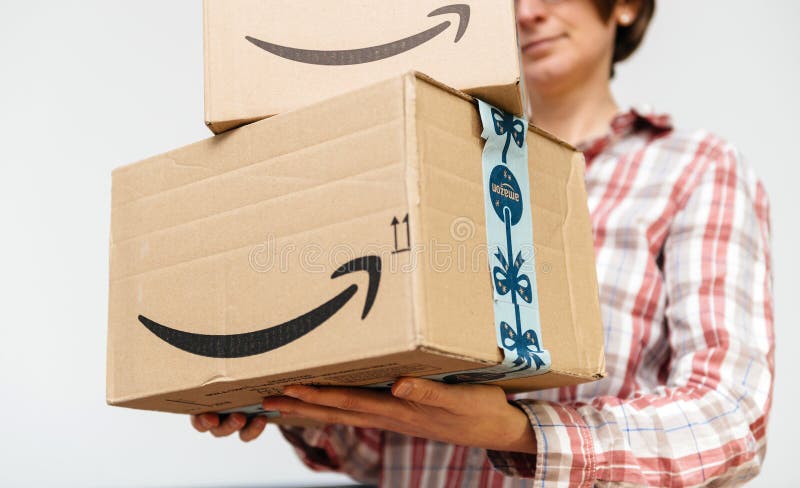 Kobieta z amazon prime kartonowymi pakuneczkami w rękach obrazy stock Kobieta z amazon prime kartonowymi pakuneczkami w rękach obrazy stock